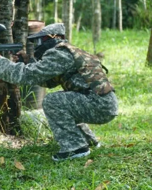Participants in masks and camouflage overalls during a First Outbound paintball session in Yogyakarta